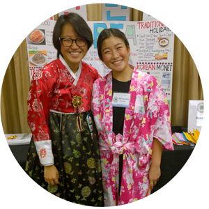 Academic Year Program (AYP) Hosts: Japanese & Korean Students Youth and adult chaperone posing with a presentation in the background!
